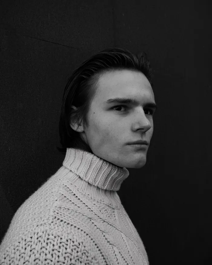 Black and white portrait of a young man in a roll-neck jumper