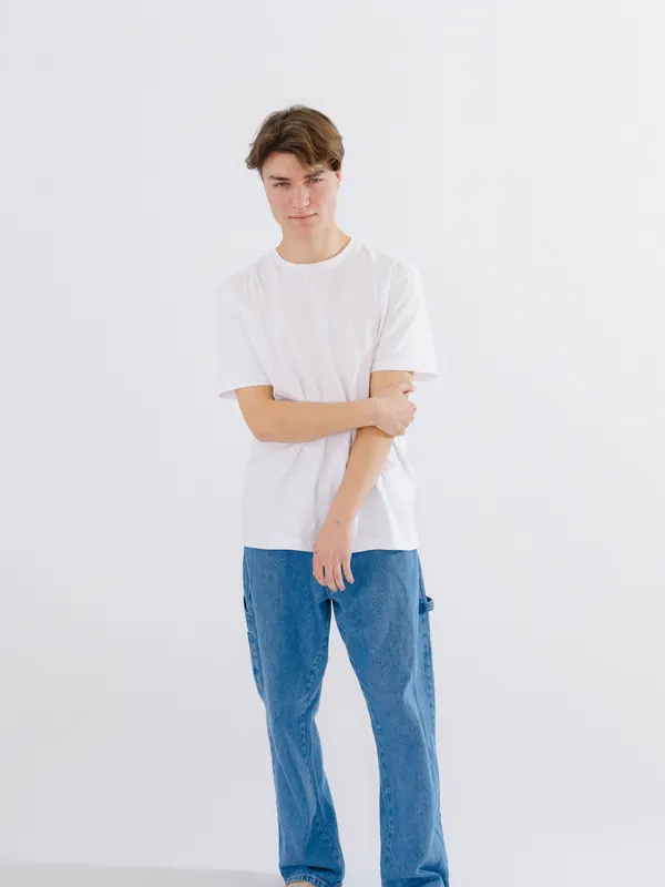 Jeune homme mince en t-shirt blanc et jean